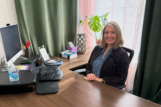 Karen Rightler smiling at her desk, representing Solandis Mental Health's commitment to patient stability.